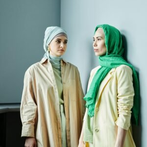 Fashionable women in hijabs showcasing modern modest fashion indoors with stylish attire.