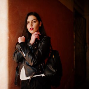 stylish brunette girl wear on leather jacket and shorts with bac